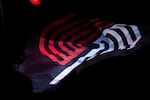 FILE - The Portland Trail Blazers logo is visible on a flag waving during a National Basketball Association game against the Detroit Pistons at Moda Center in Portland, Ore., on Sunday, Feb. 23, 2020. The Trail Blazers defeated the Pistons 107-104.
