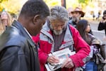 Neil Wampler, right, signs a napkin outside the federal courthouse in downtown Portland.