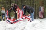 Pacific Patriots Network co-founder B.J. Soper, right, helps rebuild the roadside memorial to deceased militant LaVoy Finicum.