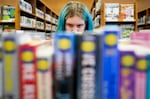 Khloe Warne, 12, browses the shelves at the Josephine Community Library, Thursday, May 18, 2023, in Grants Pass, Ore. Khloe loves drawing, writing and especially reading — in second grade, she was already reading at a sixth grade level. But she only goes to school one day a week for two hours and hasn't been on a regular school schedule for years.