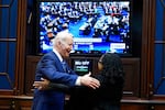 President Joe Biden goes to hug Supreme Court nominee Judge Ketanji Brown Jackson as they watch the Senate vote on her confirmation from the Roosevelt Room of the White House in Washington, Thursday, April 7, 2022.
