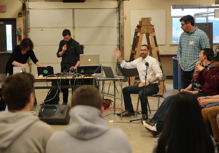 Think Out Loud host Dave Miller talks to high school students in an Oregon City High School shop class, encouraging them to participate in the show about to begin.