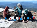 Tatiana Gibson, left, Alivia Eng, both of Georgia Tech, and Marion Nachon, of Texas A&M University, sample the composition of rocks on Mount Hood.