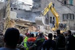 Rescuers use an excavator as they search for victims at the site of an Israeli airstrike that hit a building in Beirut, Tuesday, Nov. 26, 2024.