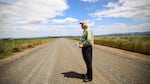 Cartographer Dave Imus stands in a country road.