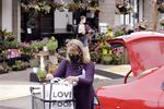 A woman wearing a face mask loads groceries into her car after shopping at a Zupan's grocery store in Portland, Ore., on Friday, May 21, 2021.