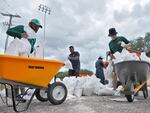 Members of the Tampa, Fla., Parks and Recreation Department help residents with sandbags on Monday, Aug. 28, 2023. Residents along Florida's gulf coast are making preparations for the effects of Tropical Storm Idalia.