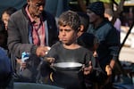 A Palestinian child queues for food in Deir al-Balah, Gaza Strip, Monday, Nov. 18, 2024.