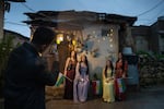 Women pose for photos dressed in traditional Kurdish clothing, which are colorful, long dresses and floral necklaces and head pieces.