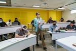 Portland State University instructor Annette Dietz walks between desks as she conducts an engineering class, Wednesday, Nov. 3, 2021 in Portland. The course is run both in-person and online as part of a pilot called "Attend Anywhere." 