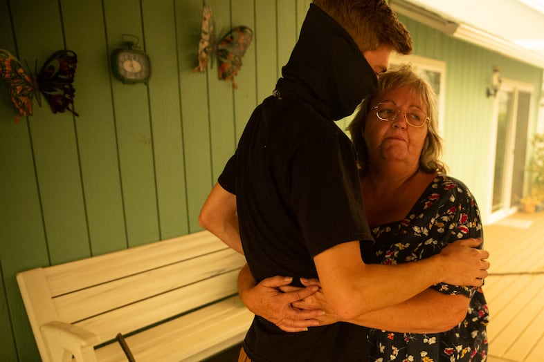 Roxane Emerson hugs her grandson after finding her home safe from the Santiam Fire near Gates, Ore., Sept. 9, 2020. Homes all around hers were destroyed.