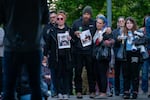 People hold pictures of their family members still unaccounted for during a vigil for the victims of the Nippon Dynawave Packaging Co. chemical implosion at R.A. Long Park in Longview, Wash., on May 26, 2026.