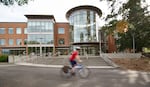 A cyclist passes before the library building at Southern Oregon University in Ashland. 