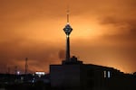  Milad (Birth) Tower, the tallest tower in Iran at 435 metres, is pictured before a lit up sky following airstrikes in Tehran on March 7, 2026. 