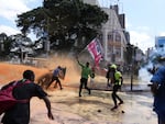 Protesters scatter as Kenya police spray water canon at them during a protest over proposed tax hikes in a finance bill in downtown Nairobi, Kenya Tuesday, June. 25, 2024. (AP Photo/Brian Inganga)