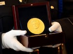 A member of the U.S. Capitol Police carries a Congressional Gold Medal for Katherine Johnson, one of NASA's "Hidden Figures," during a ceremony on Capitol Hill on Wednesday.