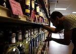 FILE - In this July 18, 2012, file photo, a worker stocks shelves at a liquor store Wednesday in Portland, Ore.