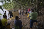 Yuly Velásquez (center in tan vest) president of a local fishers association and a clean-water advocate, meets with its members on a tributary of the Magdalena River. She has been attacked three times in the past two years for her environmental work.