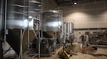A staff member at Alesong Brewing and Blending tends to tanks in its west Eugene warehouse on Nov. 24, 2025.