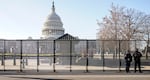 Capitol police officers stand outside of fencing that was installed around the exterior of the Capitol grounds, Thursday, Jan. 7, 2021 in Washington. The House and Senate certified the Democrat's electoral college win early Thursday after a violent throng of pro-Trump rioters spent hours Wednesday running rampant through the Capitol. A woman was fatally shot, windows were bashed and the mob forced shaken lawmakers and aides to flee the building, shielded by Capitol Police.