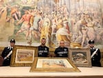 In this picture made available by the Italian Carabinieri in Parma, northern Italy, Friday, Aug. 14, 2026, Carabinieri pose near three artworks recovered following a police operation.