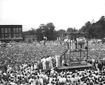 In this black-and-white photo, a huge crowd gathers around a wooden scaffold to witness the public hanging of Rainey Bethea in 1936 in Owensboro, Kentucky.