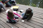 Class Of 2025 students Kaylie (left, in pink sweater) and Jason (right) are testing the acidity of different types of soil at Outdoor School's Kuratli site, near Boring, Ore.