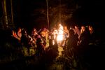 Planters sit around a camp fire on a night off. Tree planters spend months in remote locations with only each other for company and by the end of a hard season the social bonds are tight.