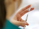 A nursing student draws up doses at a vaccine clinic held at Clackamas Town Center in this Nov. 10, 2021, file photo. 