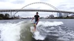 Anthony Tashnick rides the wake of a wake boat on a surfboard on the Willamette River in Portland.