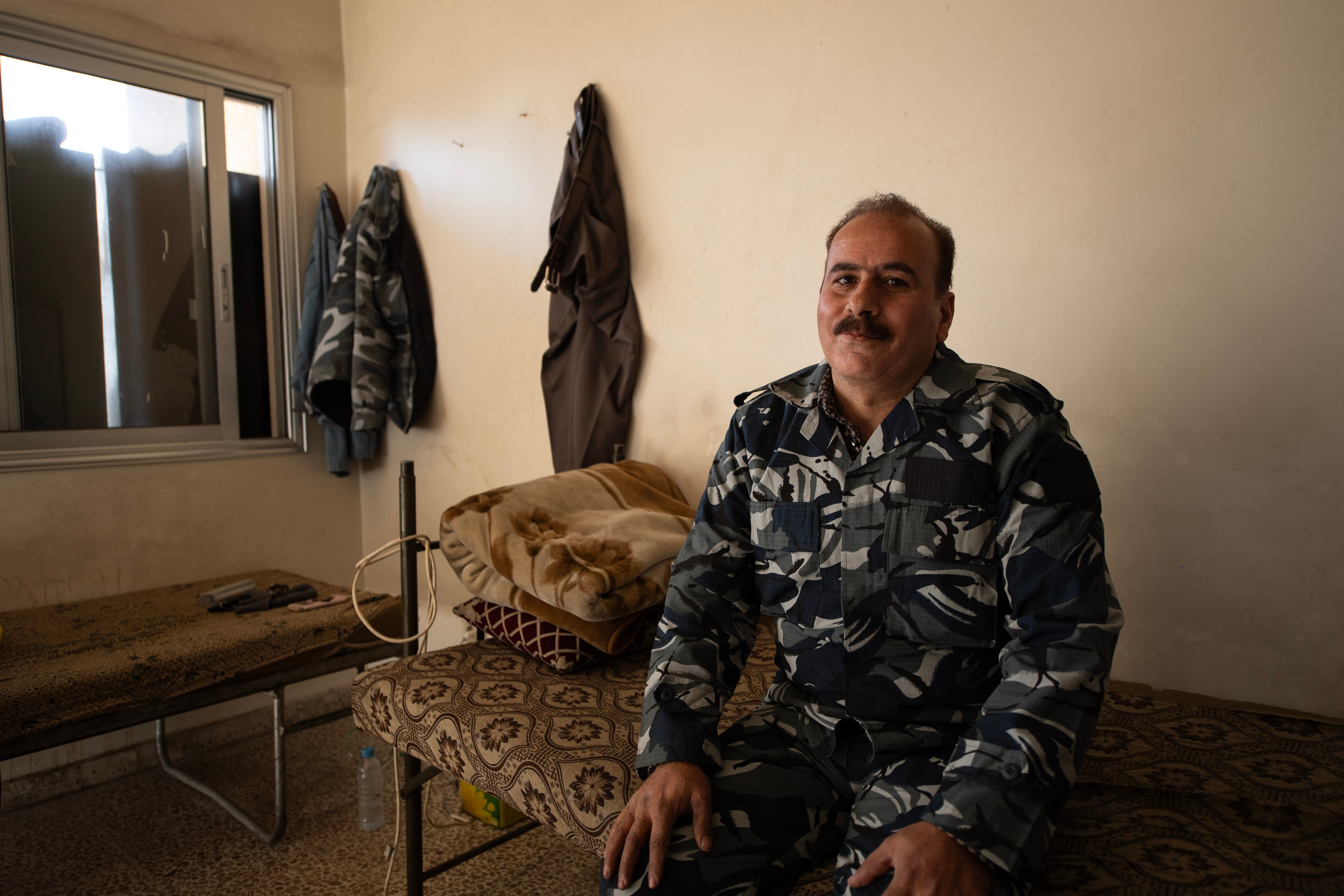 Haitham Nasrallah sits on his bed at the Kafr Sousa firehouse in southwest Damascus, wearing a uniform that identifies him as a firefighter from the old regime of dictator Bashar al-Assad.