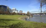 In this March 17, 2016 photo, a man walks along a pathway beside the Willamette River in Portland, Ore. Fiercely protective of its reputation as one of the most eco-friendly cities in the country, Portland is reeling from the discovery of poisonous heavy metals in the air and the ground of neighborhoods where thousands of people live, work and attend school.