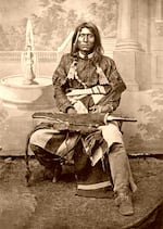In this image circa 1870, Modoc clan leader Kintpuash, also known as Captain Jack, poses in a photographer's studio in Northern California.
