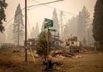 Street signs stand in front of buildings destroyed in the Holiday Farm Fire in Blue River, Ore., in this 2020 file photo. The town broke ground on a new the O'Brien Memorial Library in 2023.