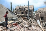A boy stands near the debris of a house that officials said was demolished in connection with the family of a suspected militant involved in a deadly attack in Kashmir in April.