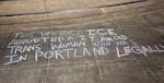 Outside the ICE building in Portland, supporters of O-J-M wrote out a message in chalk in front of the building that says "this week, ICE abducted a 24-year old trans woman who was in Portland legally."
