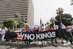 Demonstrators carry a large "No Kings" banner through downtown Los Angeles on June 14, 2025. Masses of demonstrators filled streets, parks and plazas across the United States to protest President Trump.