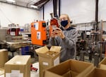 Westward Whiskey employee Alyssa McMillen checks a label while packaging a 750ml bottle at the Southeast Portland distillery in Oct. 8, 2021. The company has experienced delays in bottle deliveries from Mexico.