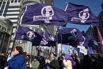 South Korean women carry flags reading "Feminist" as they march during a rally to mark International Women's Day in downtown Seoul on March 8, 2024.