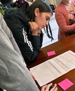 Lewis & Clark College social studies teaching candidate Madi Pastores looks at a lesson plan her classmate put together on how development impacts a neighborhood. Pastores was one of six graduate students on a field trip to a North Portland neighborhood last month.