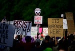Protesters hold signs during a protest at Battleship Oregon Marine Park on September 28, 2025 in Portland, Oregon.