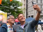 John Ogden takes a photo of himself and his husband, Kevin Bumatay, both from Portland, at the Darcelle XV Plaza grand opening.