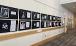 A wall inside the Downtown Eugene Public Library with pictures from the exhibit “Our Stories: Immigrants of America.”