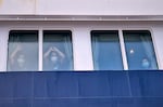 Passengers watch as others are disembarked from the hantavirus-stricken cruise ship MV Hondius at the port of Granadilla in Tenerife, Canary Islands, Spain, Sunday, May 10, 2026.