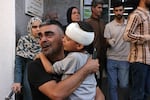 A Palestinian man carries a boy after he was treated for a head injury at the hospital, following an Israeli air strike in Rafah, in the southern Gaza Strip on Monday.