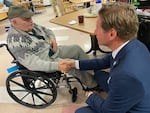 Stanley Piper talks with Rep. Dean Phillips, D-Minn., at the New Hampshire Veterans Home in Tilton, N.H. on Dec. 8, 2023.