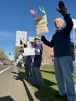 People protest on Southwest Hall Boulevard outside the Beaverton City Library.