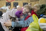 A woman holds a child and a dog in a shelter inside a building in Mariupol, Ukraine, Sunday, Feb. 27, 2022. Street fighting broke out in Ukraine's second-largest city and Russian troops squeezed strategic ports in the country's south as the prospect of peace talks remains uncertain.