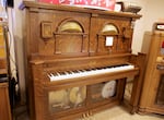 Player pianos come in many types. This one has a drum and tambourine in it.