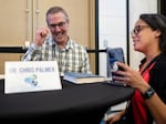 Dr. Chris Palmer (left) signs a copy of his book, Brain Energy, for Addanilka Ramos during the Metabolic Health Summit in Clearwater Fla. Palmer has been researching the keto diet for years.